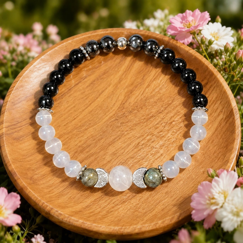 Full view of The Two Tides dark and pale bead bracelet on a wooden dish