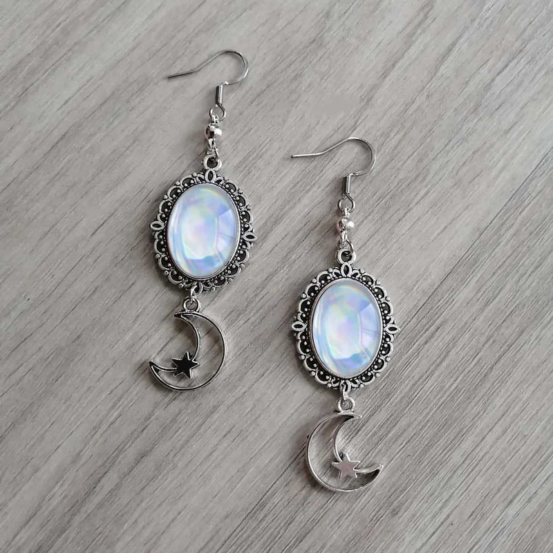 Wide flat lay of The Rose Crescent silver-tone oval and crescent drop earrings