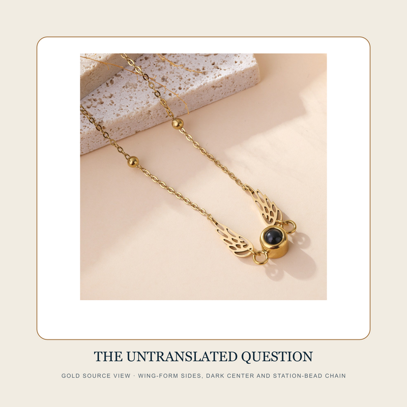 Gold source view of The Untranslated Question wing-form dark-center station-bead necklace