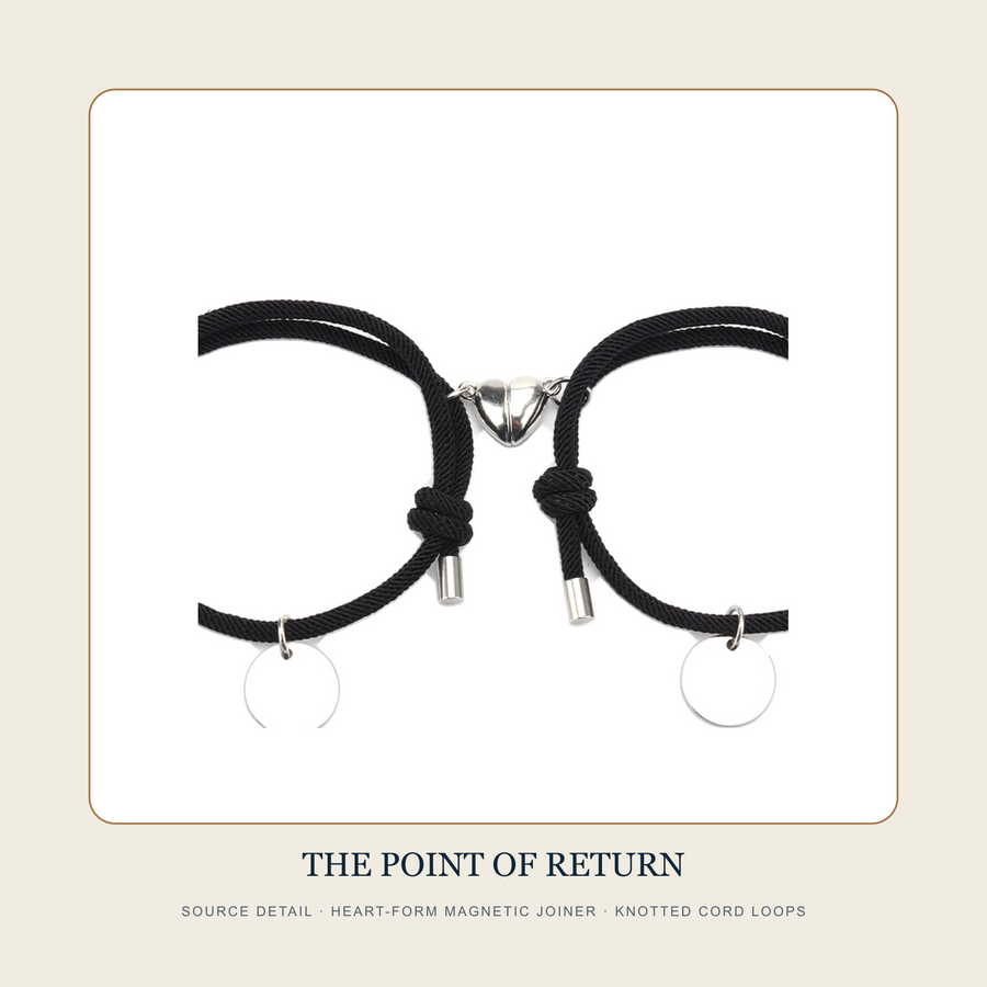 Detail source view of the heart-form magnetic joiner and knotted cord loops on the black bracelet pair