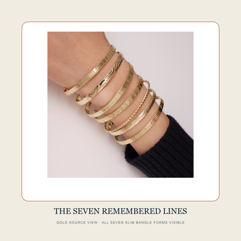 Gold source view of The Seven Remembered Lines showing all seven slim bangle forms worn together