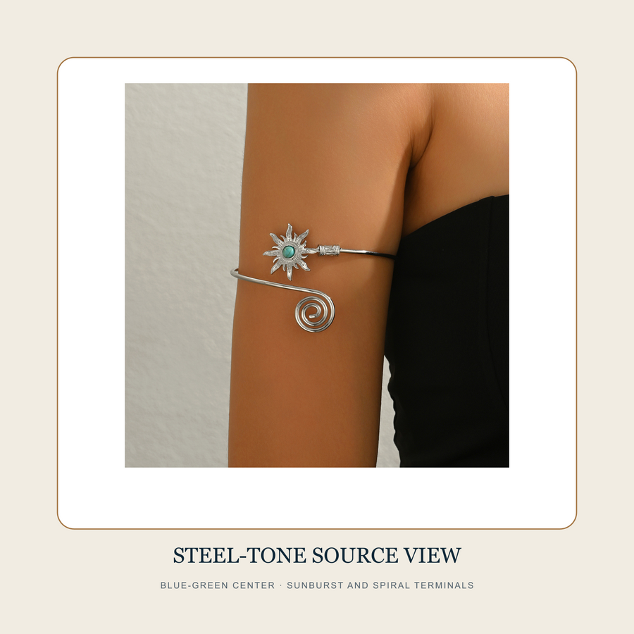 Worn source view of The Turning Sun steel-tone upper-arm cuff with blue-green center and spiral terminal