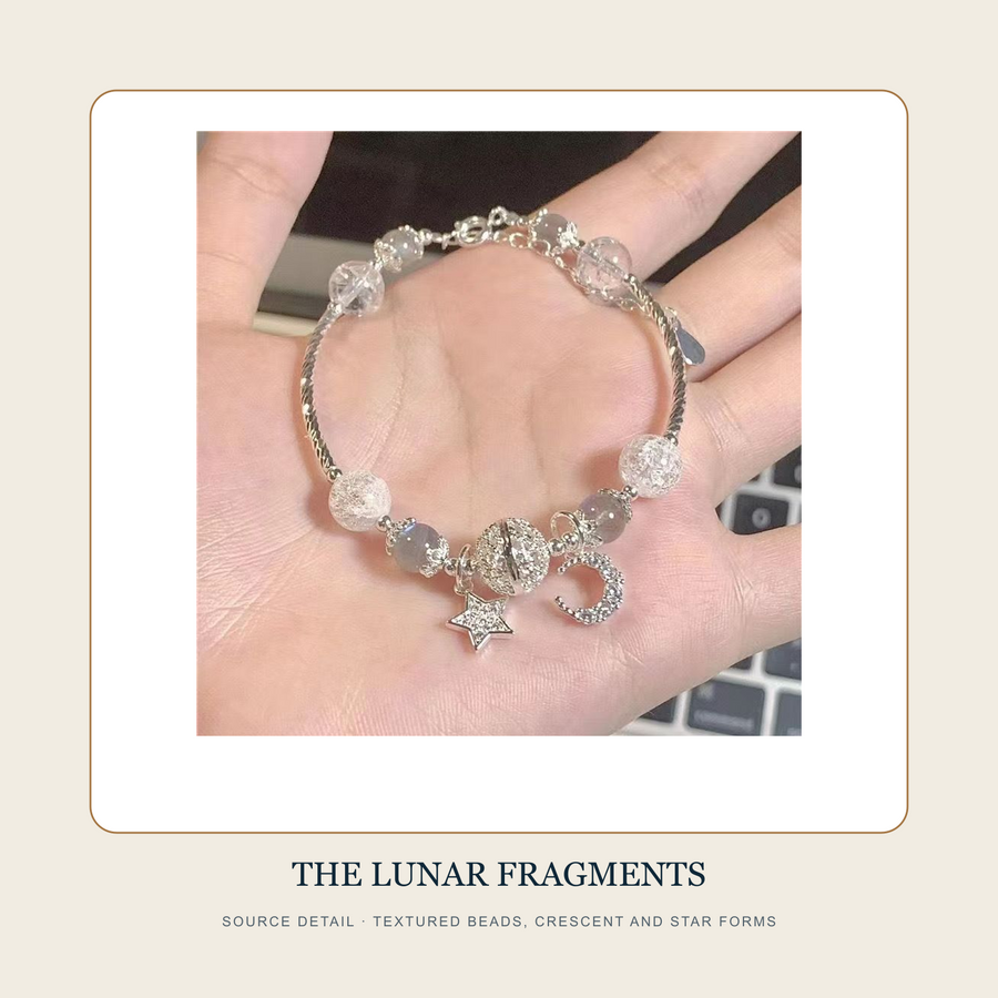 Source detail of The Broken Orbit textured grey and clear beads with crescent and star forms