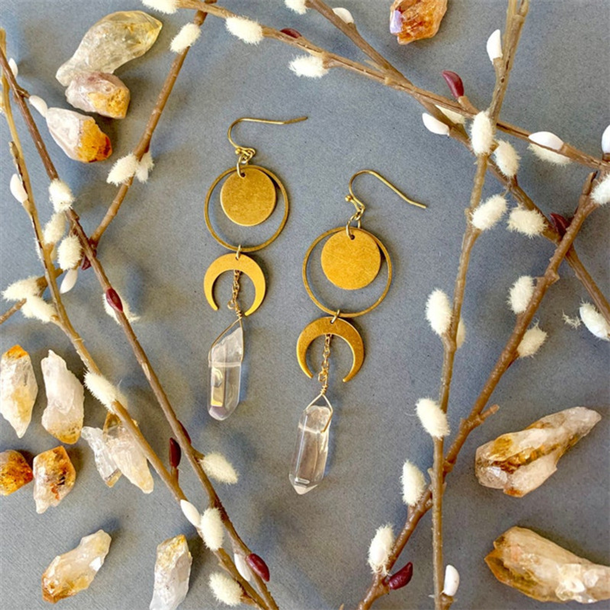 Botanical flat lay of The Crystal Crescent matching celestial drop earrings