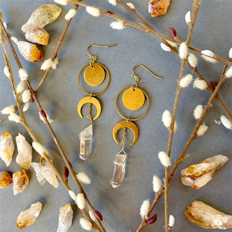 Botanical flat lay of The Crystal Crescent matching celestial drop earrings
