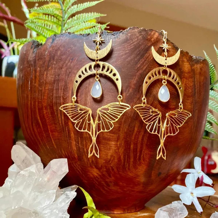 Upright display of The Moonmoth crescent and moth-style drop earrings