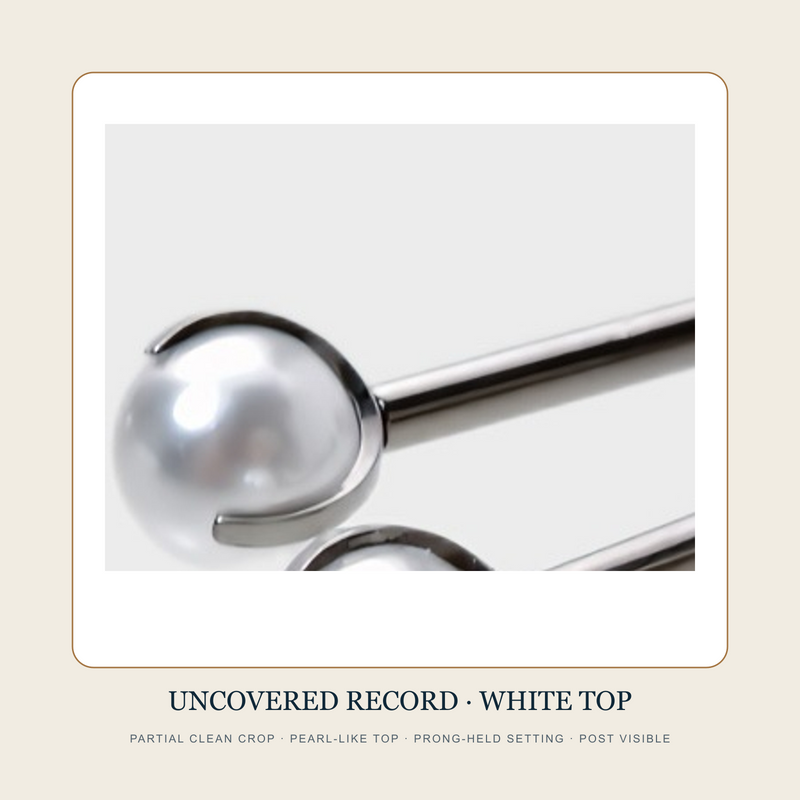Partial clean source crop of a white pearl-like prong-held top and metal-tone post