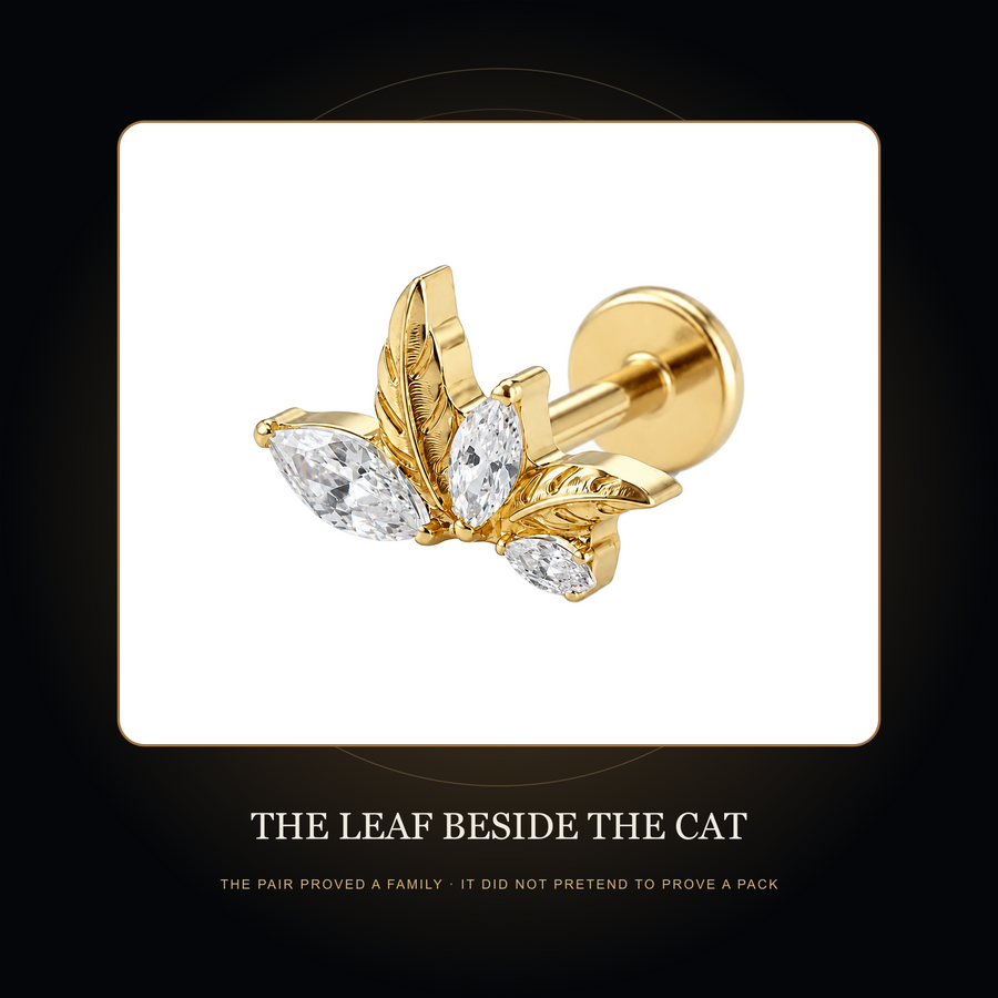 The gold-tone leaf-cluster stud in the fictional Leaf Beside the Cat story scene
