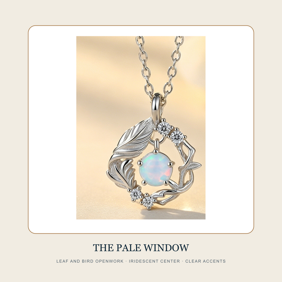Pendant detail showing leaf-and-bird openwork, pale iridescent center and small clear accents