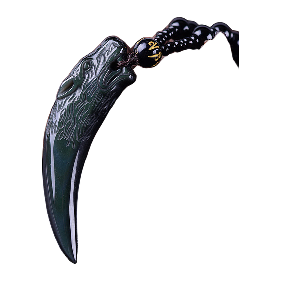 Close view of The Wolf Tooth dark curved fang pendant and carved wolf-head relief