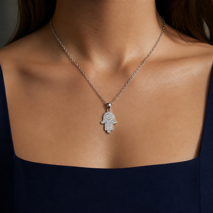 The Gilded Palm White Gold color hand pendant necklace worn with a navy dress