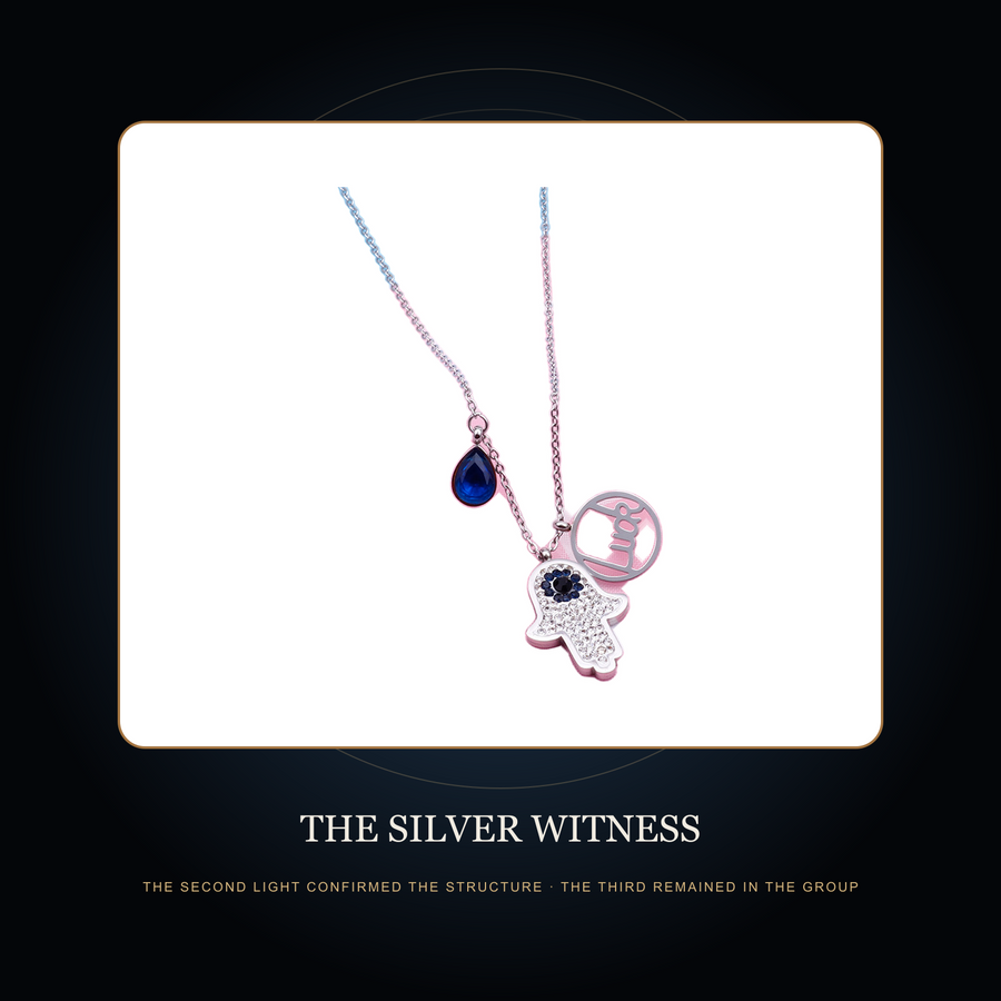 The steel-tone multi-charm necklace in the fictional Silver Witness story scene